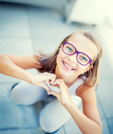 Happy child making heart shape with hands