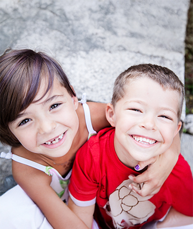 Two kids looking up to the camera smiling