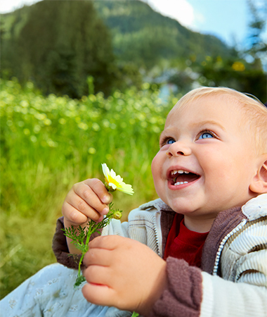 A child smiling outdoors
